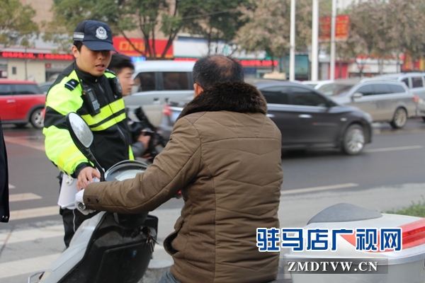 剛到路口，民警就攔住一位騎電動車闖紅燈的.JPG